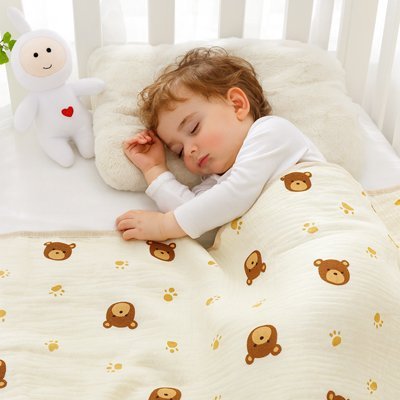 jeune garçon dors avec la couverture bébé au motif d'ourson et patte