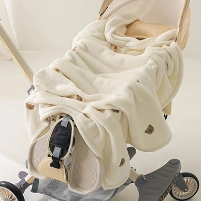 COUVERTURE BÉBÉ BLANCHE AVEC OURSON DESSUS DANS UNE POUSSETTE
